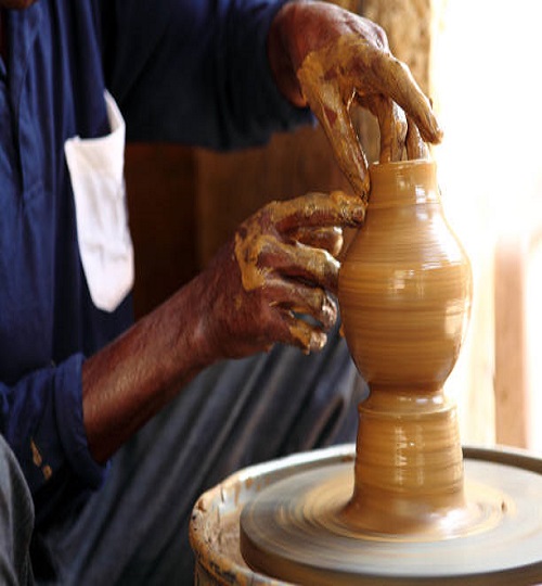 Hands of a potter making pot.