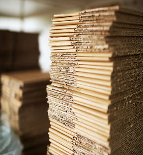 Close up picture of stacks of folded brown cardboard.