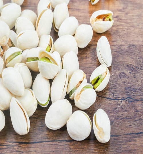 The pistachio in shell nuts on wooden table.